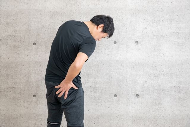 お尻を押さえる男性
