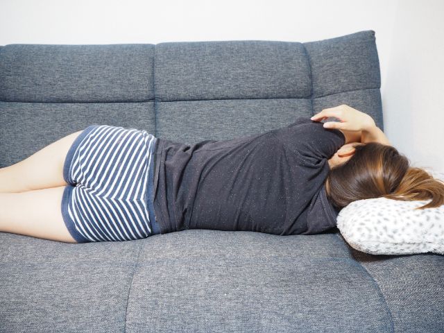 ソファで横になる女性